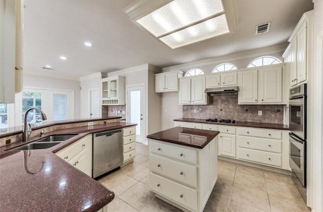 kitchen featuring dishwasher, sink, white cabinets, tasteful backsplash, and a kitchen island