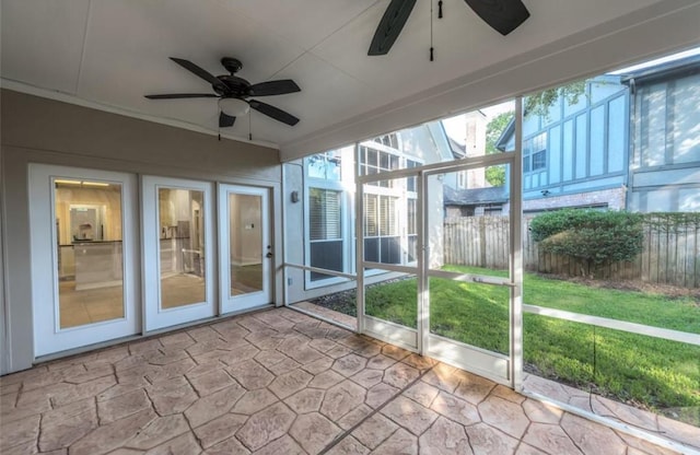 unfurnished sunroom featuring ceiling fan