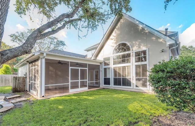 back of property featuring ceiling fan, a yard, and a sunroom