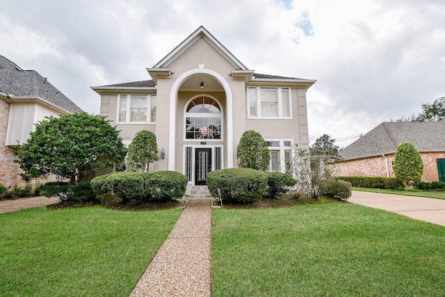 view of front of house with a front yard and stucco siding