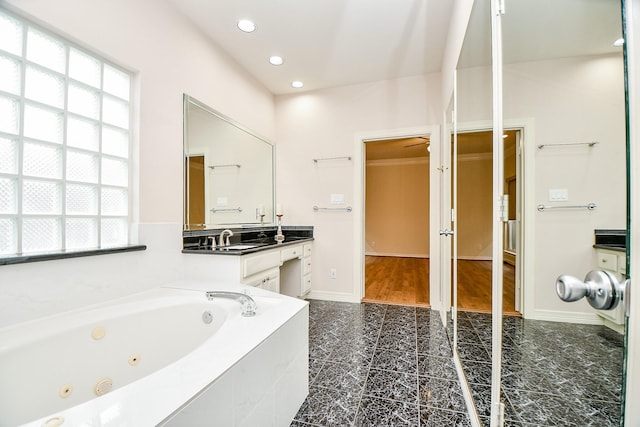 bathroom featuring vanity and tiled bath