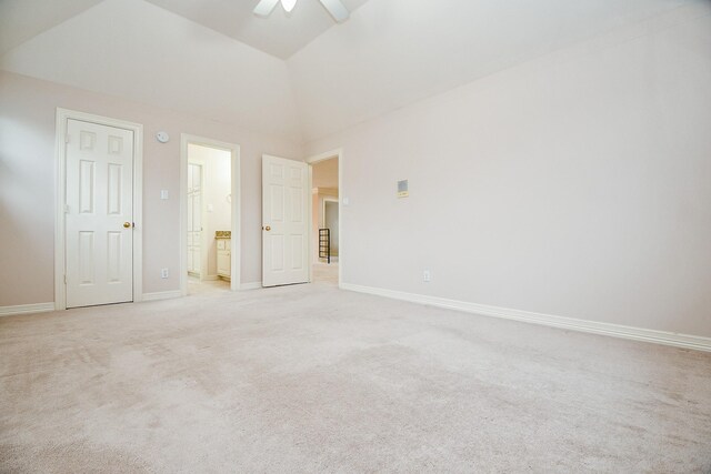 empty room featuring ceiling fan, light colored carpet, and lofted ceiling