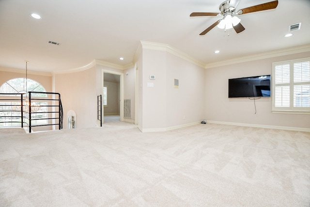 unfurnished living room with ceiling fan with notable chandelier, light colored carpet, and ornamental molding