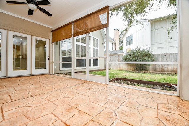 unfurnished sunroom featuring ceiling fan