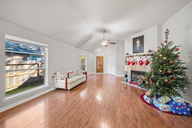 living room with hardwood / wood-style flooring, plenty of natural light, lofted ceiling, and a fireplace