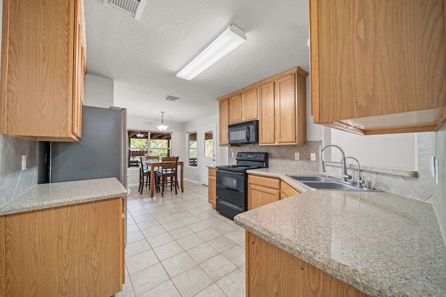 kitchen featuring backsplash, sink, black appliances, pendant lighting, and light tile patterned flooring