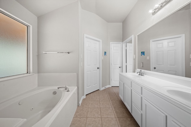 bathroom featuring tile patterned flooring, vanity, lofted ceiling, and a tub to relax in