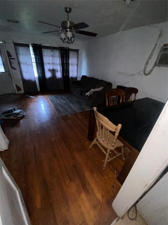 dining space with ceiling fan, wood-type flooring, and a textured ceiling