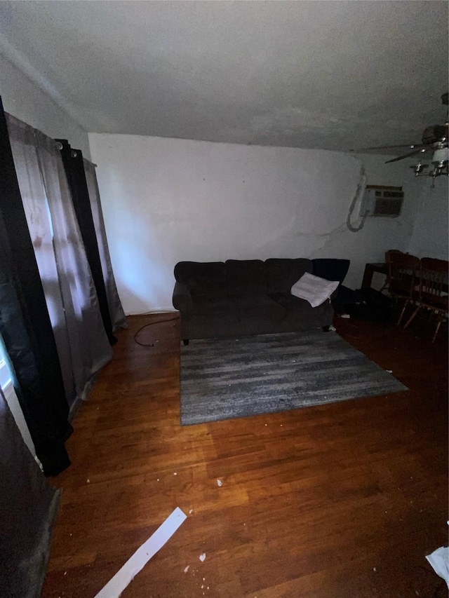 unfurnished living room with a textured ceiling, ceiling fan, dark wood-type flooring, and a wall mounted AC