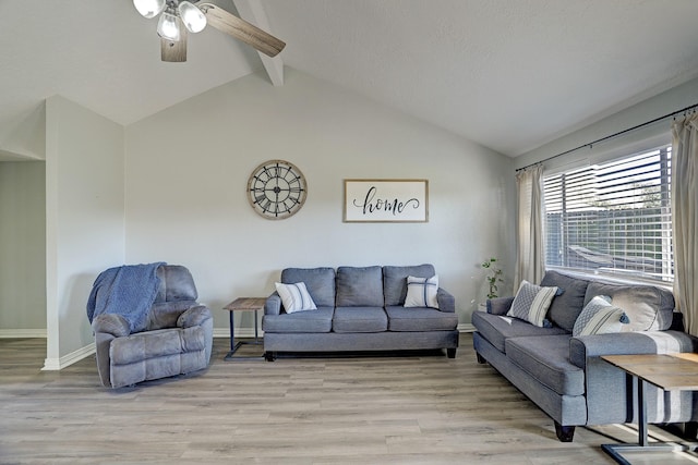 living room featuring lofted ceiling with beams, light hardwood / wood-style floors, and ceiling fan