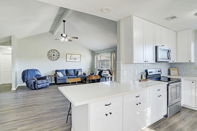 kitchen featuring kitchen peninsula, appliances with stainless steel finishes, light hardwood / wood-style floors, and white cabinetry