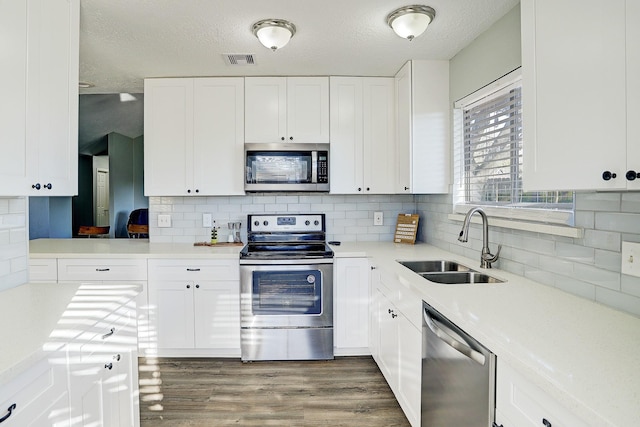 kitchen featuring white cabinets, sink, and appliances with stainless steel finishes