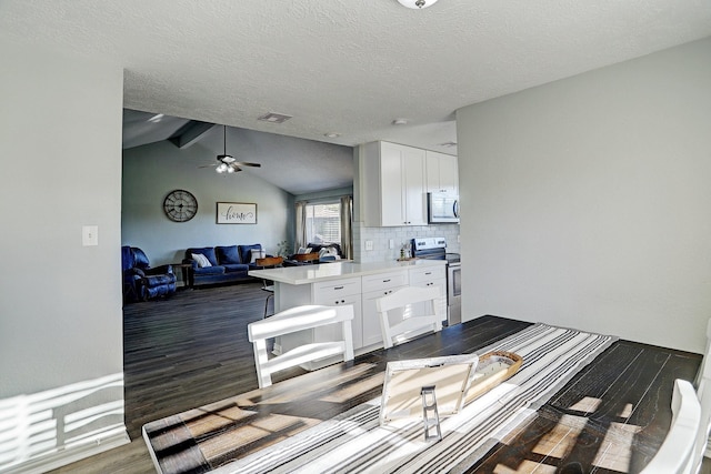 dining area featuring lofted ceiling with beams, ceiling fan, dark hardwood / wood-style flooring, and a textured ceiling