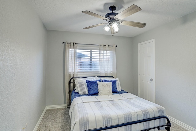 bedroom featuring a textured ceiling, carpet floors, and ceiling fan