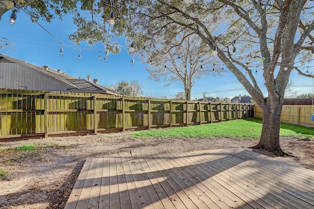 wooden deck featuring a lawn