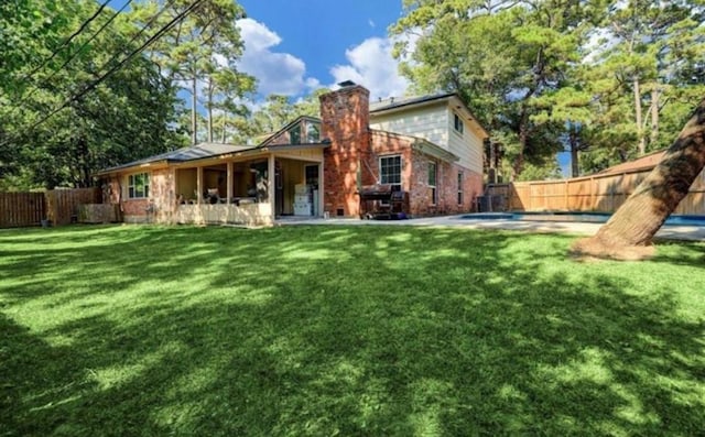 back of house with a yard and a patio