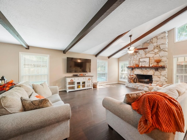 living room with lofted ceiling with beams, a healthy amount of sunlight, dark hardwood / wood-style flooring, and a fireplace