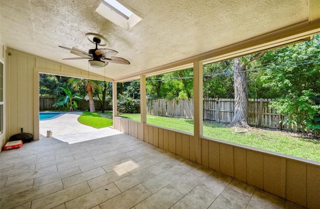 unfurnished sunroom with a skylight and ceiling fan