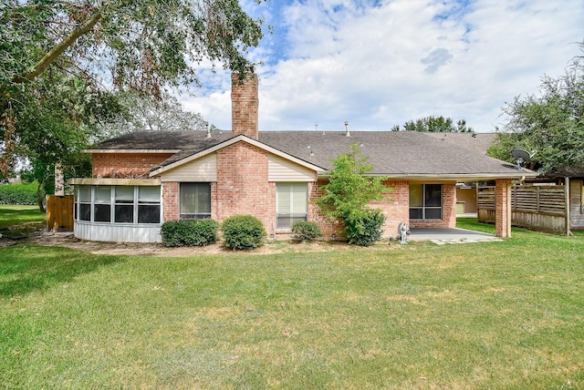 back of house with a patio area and a lawn