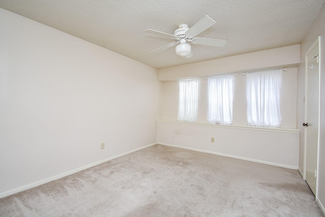 carpeted empty room featuring ceiling fan and a textured ceiling