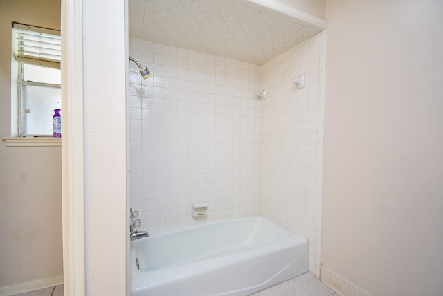 bathroom featuring tile patterned floors and tiled shower / bath