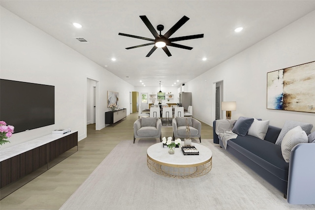 living room with light wood-type flooring and ceiling fan