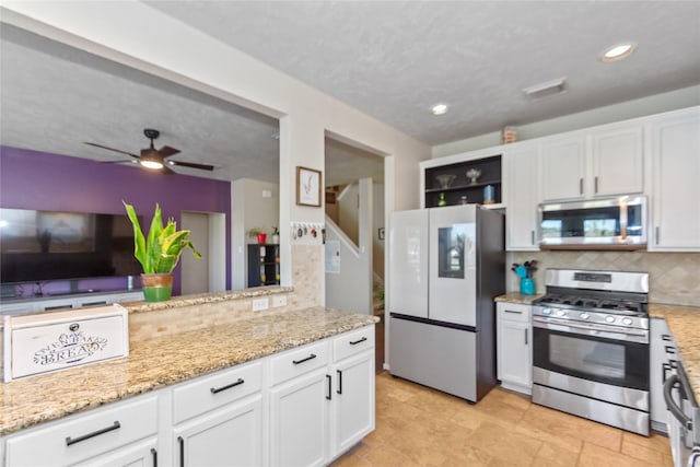 kitchen with ceiling fan, decorative backsplash, white cabinets, and appliances with stainless steel finishes