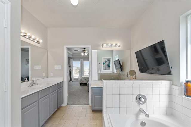 bathroom with tile patterned floors, a bathing tub, ceiling fan, and vanity