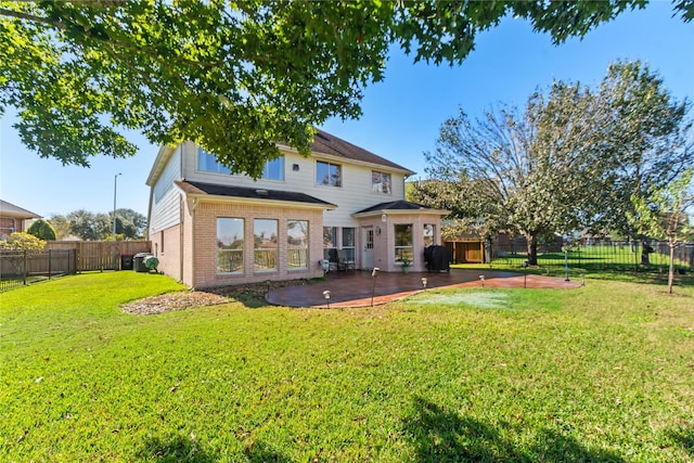 back of property with a yard and a patio