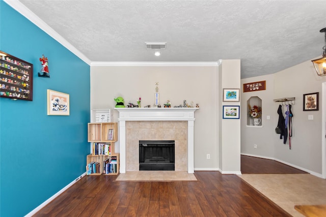 unfurnished living room with dark hardwood / wood-style flooring, ornamental molding, and a tiled fireplace