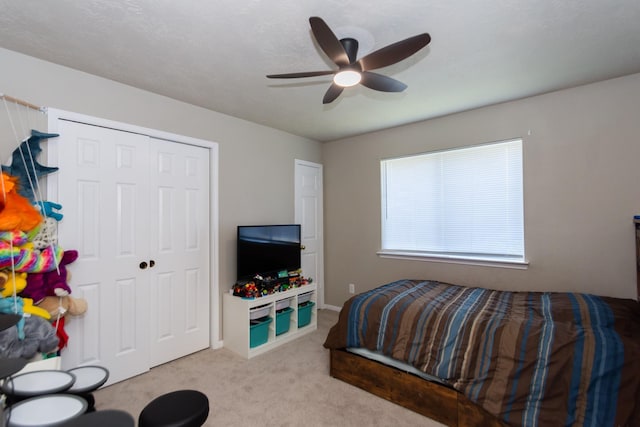 bedroom with light carpet, a closet, and ceiling fan