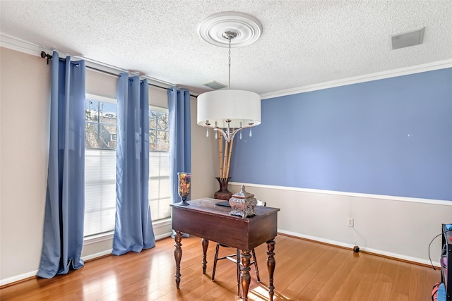 home office featuring hardwood / wood-style floors, a textured ceiling, and ornamental molding