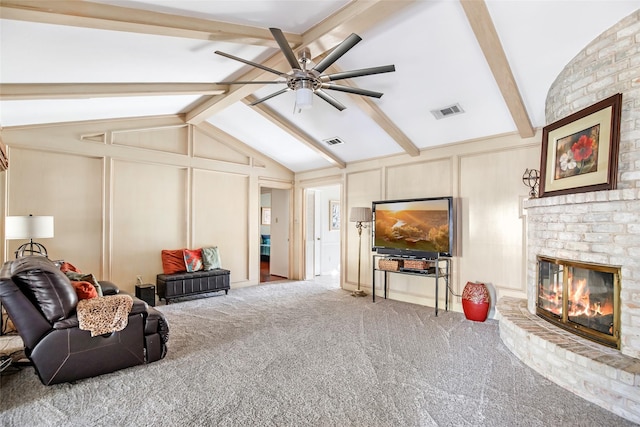 living room featuring a fireplace, carpet floors, lofted ceiling with beams, and ceiling fan