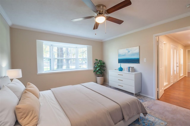 bedroom with light hardwood / wood-style floors, ceiling fan, and crown molding