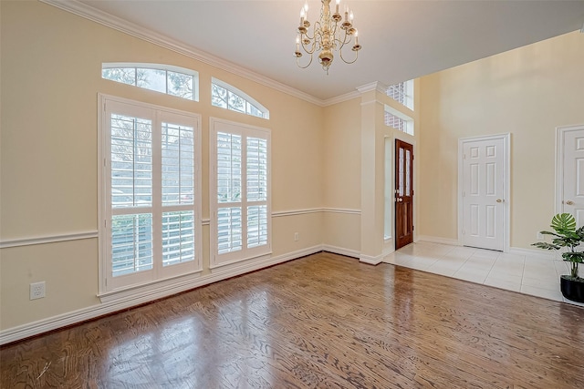 entryway featuring an inviting chandelier, ornamental molding, and light hardwood / wood-style flooring