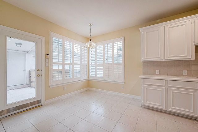 unfurnished dining area with light tile patterned floors and a chandelier