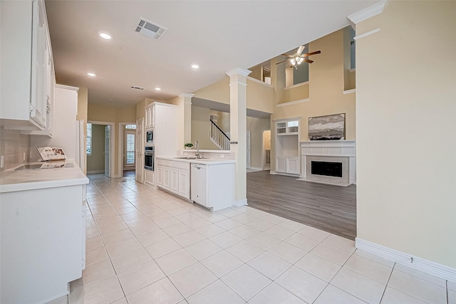 kitchen with sink, ceiling fan, appliances with stainless steel finishes, light tile patterned flooring, and white cabinetry