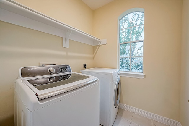 clothes washing area with light tile patterned floors and washer and dryer