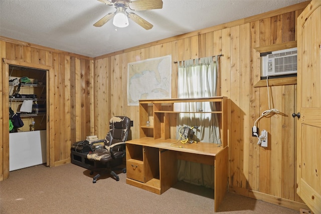 carpeted office with a textured ceiling, ceiling fan, and wooden walls