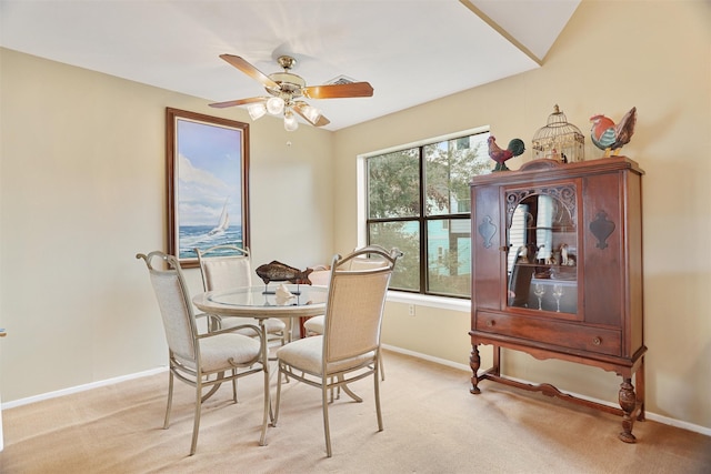 carpeted dining space with ceiling fan