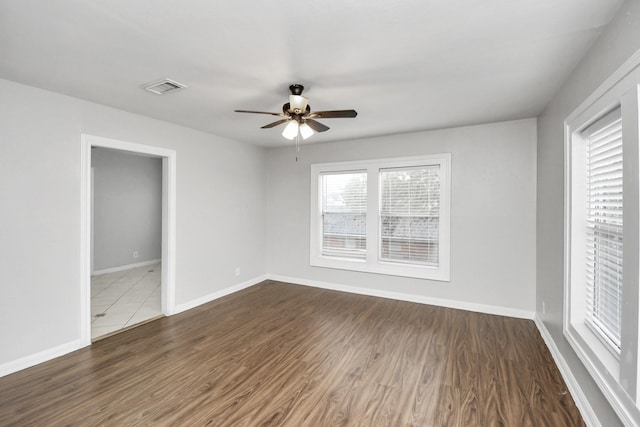 unfurnished room with ceiling fan and dark wood-type flooring