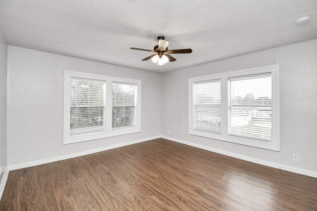 spare room with a wealth of natural light, dark wood-type flooring, and ceiling fan