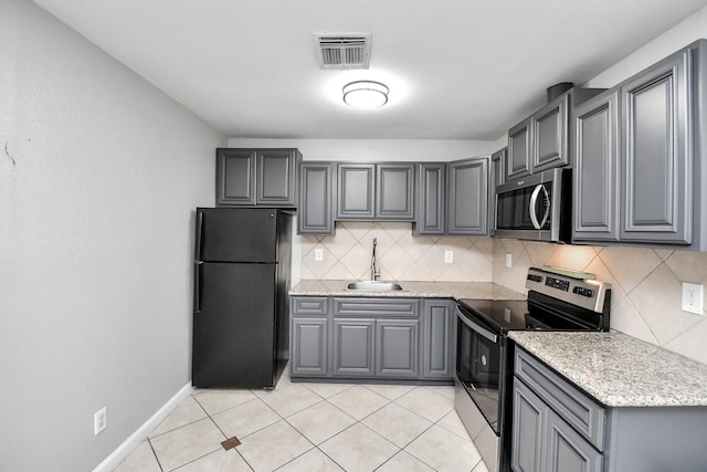 kitchen with decorative backsplash, stainless steel appliances, gray cabinets, and sink