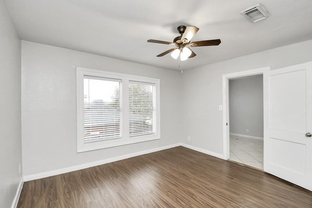 unfurnished room with ceiling fan and dark hardwood / wood-style flooring