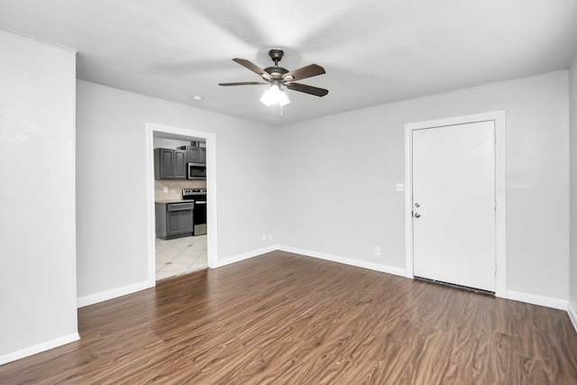 spare room with ceiling fan and light wood-type flooring