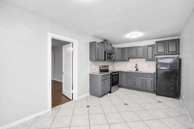 kitchen featuring decorative backsplash, gray cabinets, sink, and stainless steel appliances