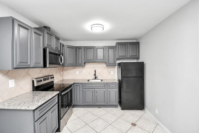 kitchen with backsplash, sink, gray cabinetry, and stainless steel appliances