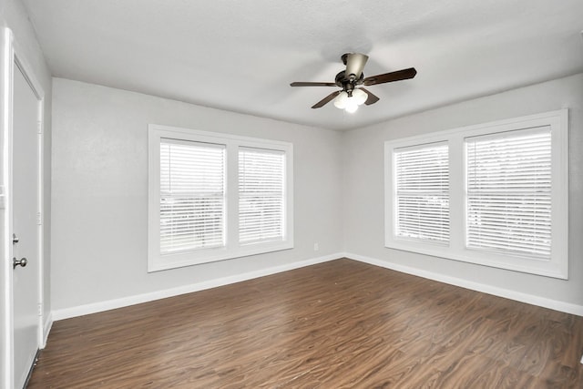 empty room with ceiling fan and dark wood-type flooring