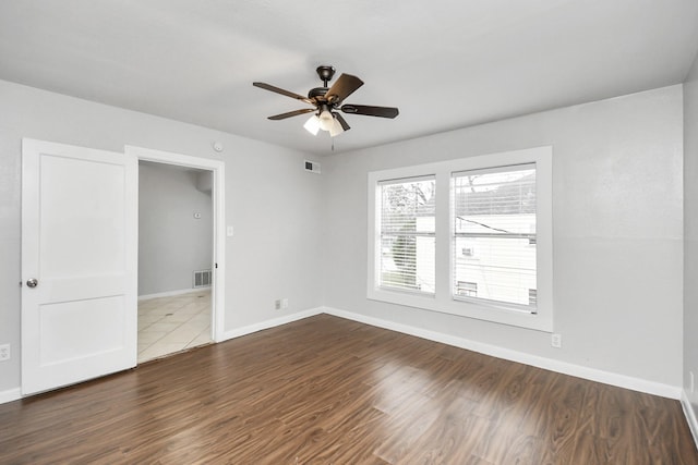 empty room with hardwood / wood-style flooring and ceiling fan