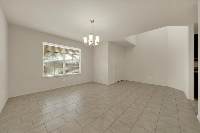 tiled spare room with an inviting chandelier